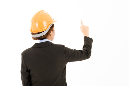 Young confident asian woman, orange safety hat, black suit, blue shirt on white pointing finger. For engineering, construction, architecture, business man concepts.の写真素材