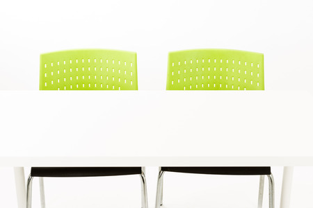 White modern office table with green chairs on white background. For modern office furniture, job interview, job seeking, performance review, job review year end, one on one talk, career talk concept.の写真素材