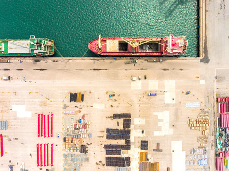 Aerial view of large shipping port with goods cargo containers, cranes and shipping vessels. Taken...