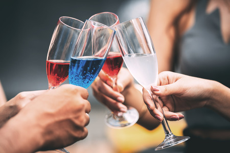 Friends hand holding champagne glasses making a toast. Taken in real pub settings.