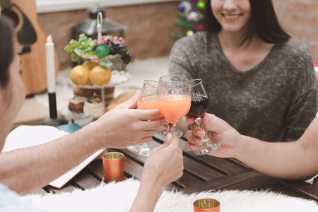 Group of friends having a party outdoor during lunch time, cheering and toasting.の写真素材