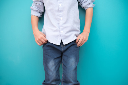 Young boy isolated in blue. Handsome early teenage boy portrait. Cool looking pose.の写真素材