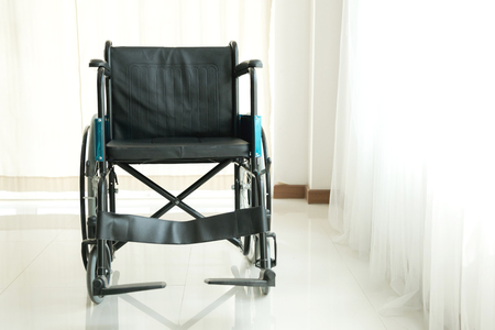 Empty wheel chair in hospital. With window and sun light on the right.の写真素材