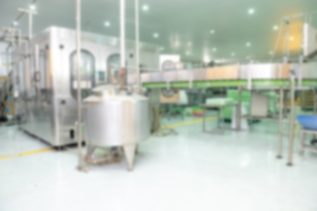 Blur background of Beverage production line. A conveyor belt full of empty plastic bottle going into...