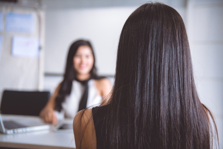 Job interview in office office. Asian woman in business dress being interviewed by her woman employer. Successful businesswoman concept.の写真素材