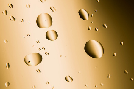 Water drop on soft shiny gold background