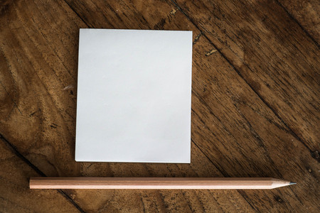 White notepad and pencil on wood tableの写真素材