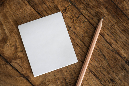 White notepad and pencil on wood tableの写真素材