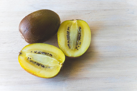 KIWI gold half slice on wood tableの写真素材