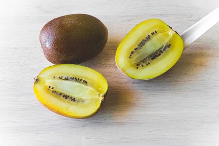 KIWI gold half slice on wood tableの写真素材