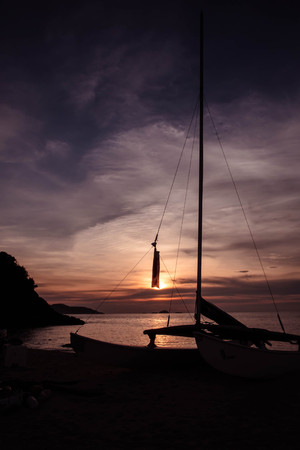 silhouette sailboat at the beach in sunsetの写真素材