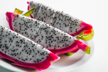 Slices dragon fruit in dish on white backgroundの写真素材