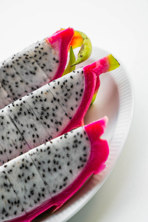 Slices dragon fruit in dish on white backgroundの写真素材