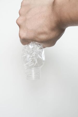 Male hand squeeze and pour down plastic bottleの写真素材