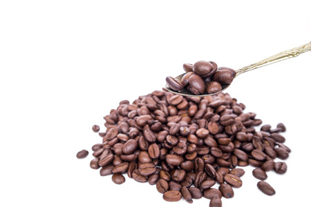 Close-up roasted coffee bean on classic gold spoon and background, isolated on white backgroundの写真素材