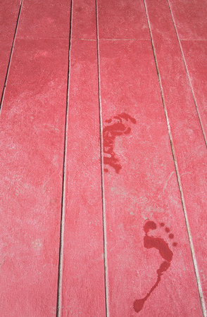 water footprint on maroon wooden floorの写真素材