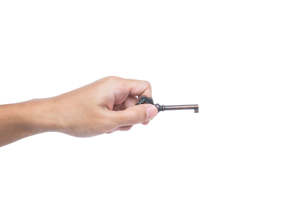 Hand holding old vintage copper key, isolated on white backgroundの写真素材