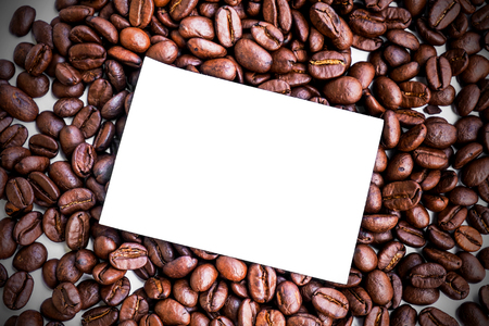 Blank paper note on roasted coffee beansの写真素材
