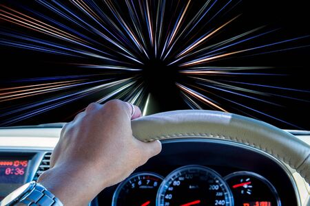 Hand of driver holding steering wheel with abstract speed motion light lines backgroundの写真素材