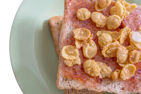 Toasted bread fill with strawberry jam and sweet cornflakes, isolated on white backgroundの写真素材
