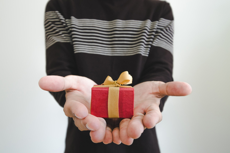 Little gift box on hands, shallow depth of field, selective focus on gift box, on white backgroundの写真素材