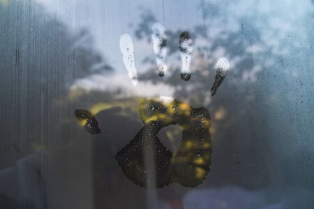 Hand print on hazy glass in the morningの写真素材