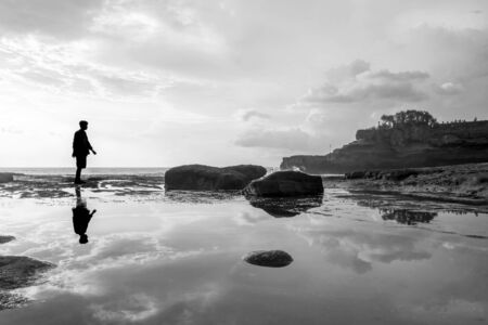 Silhouette a man with reflection on the water on the island, black and whiteの写真素材