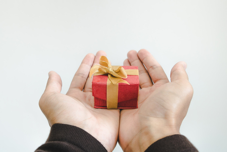 vintage tone, Hand holding, giving or receiving gift box, on white backgroundの写真素材