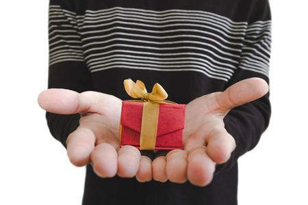 Hand holding, giving or receiving gift box, shallow depth of field, selective focus on gift box, isolated on white backgroundの写真素材