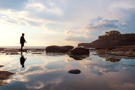 Silhouette a man with reflection on the water on the islandの写真素材