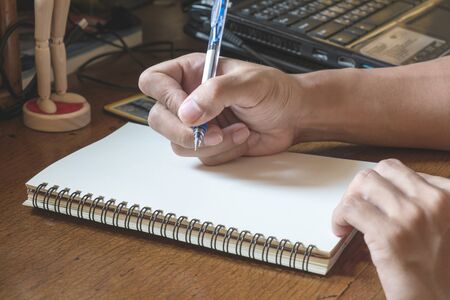 Male hand writing notebook on working table, vintage toneの写真素材