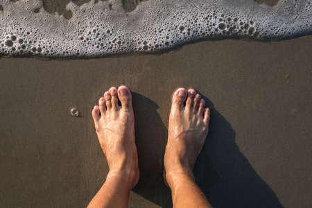Feet standing on the beachの写真素材