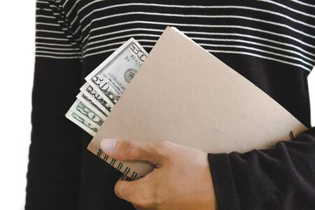A man holding book with cash hiding inside, isolated on white backgroundの写真素材