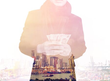 Double exposure, businessman holding cash with cityscape, abstract concept, vintage toneの写真素材