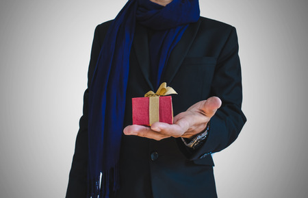 Businessman in casual suit with little gift box on hand, selective focus on gift boxの写真素材