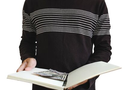 A man opened book with cash hiding inside, selective focus, isolated on white backgroundの写真素材