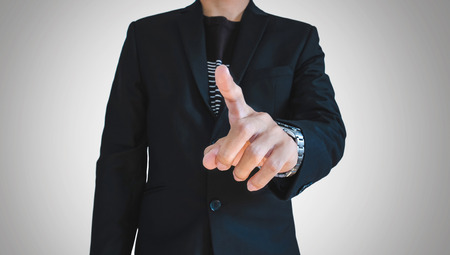 Businessman in casual suit pointing finger, selective focus on handの写真素材