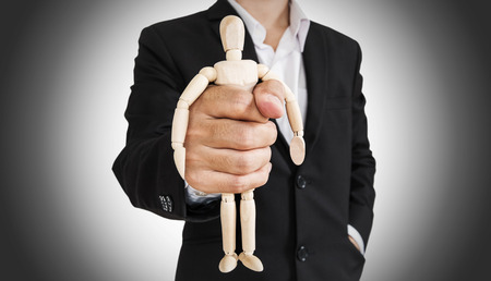 Businessman holding wooden figure, abstract conceptの写真素材