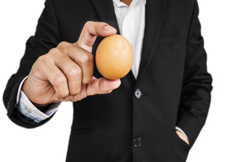 Businessman holding cracked egg, isolated on white backgroundの写真素材