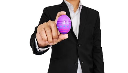 Businessman holding Easter egg, isolated on white backgroundの写真素材