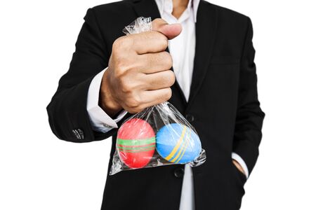Businessman holding plastic bag of Easter egg, isolated on white backgroundの写真素材