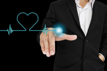 Businessman pointing to screen with electric heart pulse interfaceの写真素材