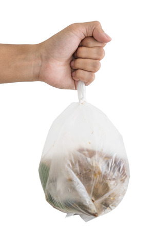 Hand holding bag of garbage waste, isolated on white backgroundの写真素材