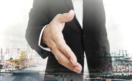 Businessman extending hand with capital city background, selective focus, shallow depth of fieldの写真素材