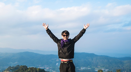 Asian guy on top of mountainの写真素材