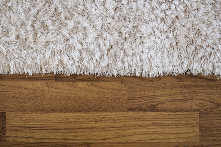 Close up fluffy luxury carpet on laminate wood floorの写真素材