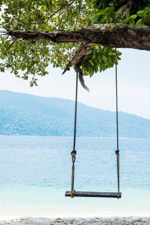 Wooden swing on the beach in the islandの写真素材