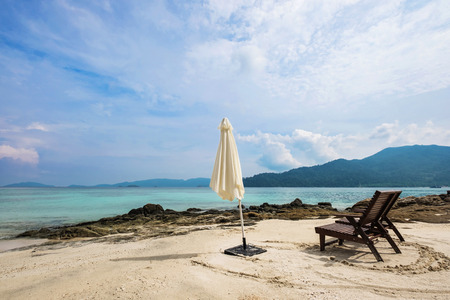 Beach chairs with parasol on the beach in cloudy dayの写真素材
