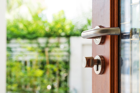 Close-up wooden door opening with blur garden backgroundの写真素材