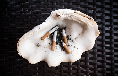 Natural ashtray made of shell, on weave tableの写真素材